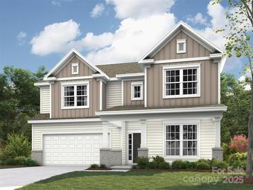 Charming two-story home featuring a two-car garage, neutral siding, and a well-manicured front lawn and landscape at 4113 Dahlia Dr # Cgw0120, Harrisburg, NC 28075