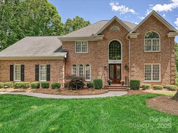 Charming brick home with manicured lawn, mature trees, and inviting entryway at 4701 Pineland Pl, Charlotte, NC 28277