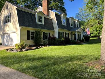 Charming two-story home with a well-maintained lawn and manicured landscaping in a mature neighborhood at 4905 Montibello Dr, Charlotte, NC 28226