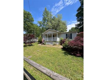 Charming single-story home with a cozy front porch, lush lawn, and vibrant landscaping at 515 Willow St, Lincolnton, NC 28092