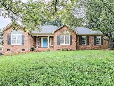 Charming brick home with arched windows and a well-maintained lawn at 6231 Kentwood Dr, Kannapolis, NC 28081