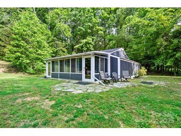 Charming sunroom featuring screened windows, stone patio, and outdoor seating, perfect for relaxing in nature at 715 Potneck Rd, Salisbury, NC 28147
