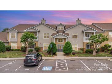 Inviting exterior of a two-story condo building with well-maintained landscaping and ample parking at dusk at 11707 Ridgeway Park Dr, Charlotte, NC 28277