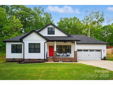 Charming new construction home featuring a red front door, 2-car garage, and manicured lawn at 1212 Mason Way, Mount Holly, NC 28120