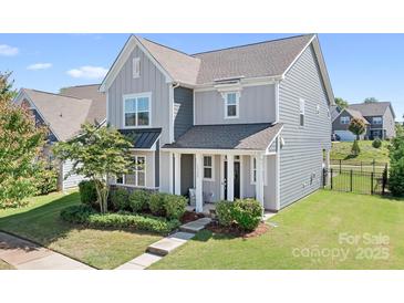 Charming two-story home with gray siding, manicured landscaping, and a welcoming front porch at 13359 Caite Ridge Rd, Davidson, NC 28036