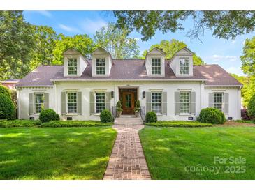 Charming white brick home featuring dormer windows, lush lawn, and a brick walkway leading to the front door at 2900 Wickersham Rd, Charlotte, NC 28211