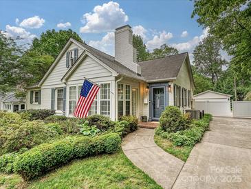 Charming home features manicured landscaping, a welcoming entrance, and an American flag waving proudly at 3128 Country Club Dr, Charlotte, NC 28205