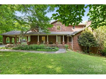 Charming brick home with covered porch and manicured front lawn creating an inviting curb appeal at 332 York Spann Rd, Hamptonville, NC 27020