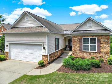 Charming single-Gathering home with manicured lawn, two-car garage, stone accents, and neutral color palette at 54053 Flycatchers Ct, Fort Mill, SC 29707