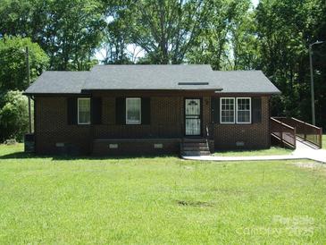 Charming brick home featuring a well-manicured lawn and classic architectural details at 556 Roundtree Cir, Chester, SC 29706