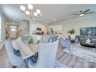 Open-concept living room showcasing modern decor, an elegant chandelier, and seamless flow to the kitchen at 574 Altamonte Dr, Clover, SC 29710