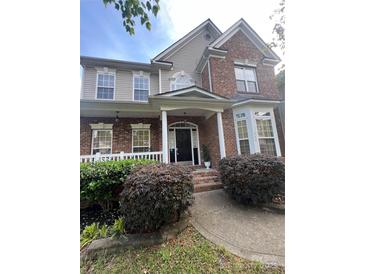 Charming home exterior with a welcoming front porch, manicured landscaping, and brick accents at 715 Larimer Ln, Charlotte, NC 28262