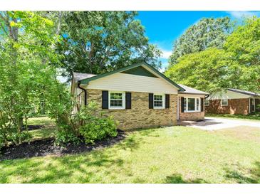 Charming brick home with black shutters and lush greenery provides an inviting curb appeal at 8303 Hemby Wood Dr, Indian Trail, NC 28079