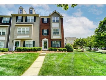 Charming brick and siding townhome with well-manicured lawn and inviting entrance at 9204 Washam Potts Rd, Cornelius, NC 28031