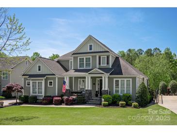 Charming home with manicured lawn, covered front porch, and American flag in a lovely, residential neighborhood at 1148 Wessington Manor Ln, Fort Mill, SC 29715