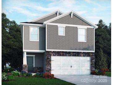 Charming two-story home boasts stone accents, gray siding, and a two-car garage, all in a well-manicured lawn at 1342 31St St, Conover, NC 28613