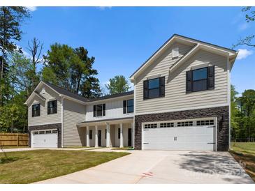 Charming new construction home with a stone base, siding exterior, and attached two-car garage at 1604 Breezewood Dr, Charlotte, NC 28262