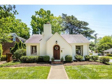 Charming white Tudor-style home with a beautiful wooden door and manicured landscaping at 2033 Charlotte Dr, Charlotte, NC 28203