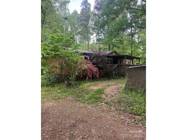 Charming single-story home nestled in a lush, wooded setting with a covered front porch and inviting curb appeal at 208 James Dr, Cleveland, NC 27013