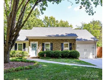 Charming brick home with a well-manicured lawn and inviting walkway leading to the front door at 2401 Birnen Dr, Charlotte, NC 28210