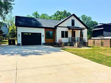 Charming new construction home featuring a black garage door, stylish wood and white siding, and a spacious driveway at 2907 Lake Ave, Charlotte, NC 28208