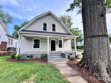 Charming two-story home featuring a cozy front porch and meticulously landscaped front yard with a beautiful large shade tree at 419 S Spencer Ave, Spencer, NC 28159