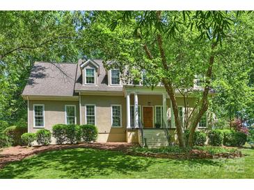 Charming home with a classic design, featuring a covered front porch and mature trees providing shade at 9526 Greyson Ridge Dr, Charlotte, NC 28277