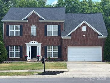 Traditional two-story brick home with a well-manicured lawn and a two-car garage at 12244 Wallace Ridge Dr, Charlotte, NC 28269