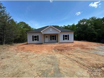 Charming single-story home featuring gray siding, a gable roof, and a welcoming front porch in a serene wooded setting at 1247 Beltline Rd # 1, Chester, SC 29706