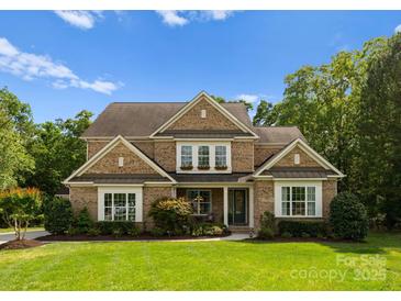 Charming brick home with manicured lawn, lush landscaping, and a welcoming front porch at 1410 Smoketree Ct, Waxhaw, NC 28173