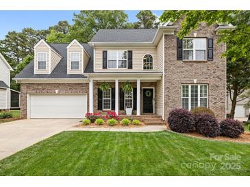 Charming two-story home with brick and siding, manicured lawn, and inviting front porch at 14849 Middlesborough Dr, Matthews, NC 28104