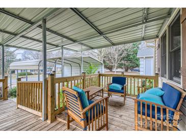 Inviting covered porch with wooden furniture and blue cushions, perfect for relaxing outdoors at 201-A Ewing Dr, Belmont, NC 28012