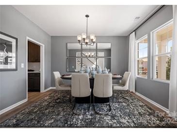Contemporary dining room features a modern chandelier, a mirrored wall, and a stylish rug under the dining table at 2010 Puddle Pond Rd, Indian Trail, NC 28079