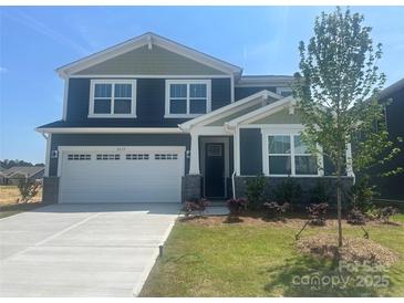 Two-story home featuring a two-car garage, manicured lawn, and pleasant landscaping at 2635 Tillman St, Monroe, NC 28112