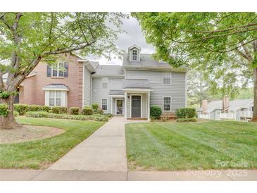 Inviting two-story townhome with a well-manicured lawn and a charming walkway leading to the front door at 2916 Iron Gate Ln, Charlotte, NC 28212