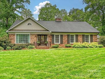 Charming brick home with a manicured front lawn, mature trees, and shutters at 5624 Warewhip Ln, Charlotte, NC 28210