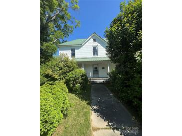 Charming two-story home with a metal roof and mature trees in a lush yard at 723 Pee Dee Ave, Albemarle, NC 28001