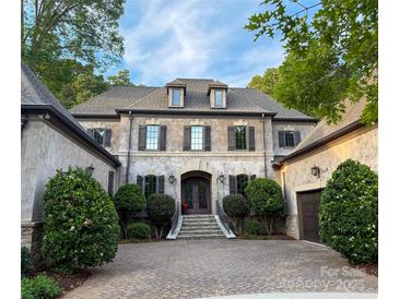 Elegant two-story home featuring a symmetrical facade, dormer windows, and manicured landscaping at 7906 Skye Lochs Dr, Waxhaw, NC 28173
