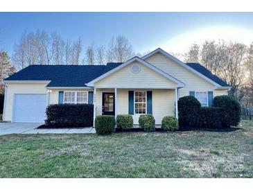 Charming single-story home with yellow siding, blue shutters, and a well-manicured front lawn at 8809 Reedy Creek Rd, Charlotte, NC 28215