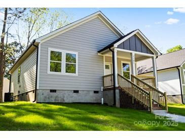 Charming single-story home featuring gray siding, a welcoming front porch and a well-maintained green lawn at 1101 Kenly St, Salisbury, NC 28144