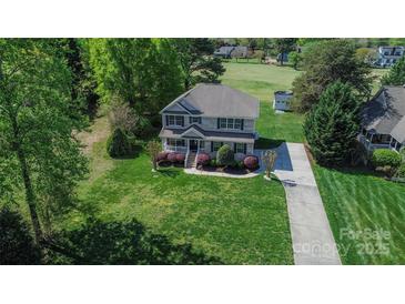 Charming two-story home featuring lush landscaping and a well-manicured lawn at 136 Wood Duck Loop, Mooresville, NC 28117