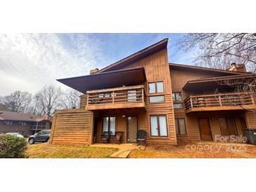 Charming two-story townhouse boasts a wooden exterior, private balcony, and cozy front porch seating at 1832 J Julian Ln, Charlotte, NC 28208
