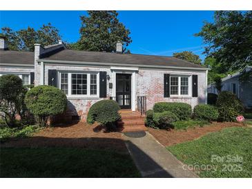 Charming, whitewashed brick home with manicured landscaping, black shutters, and a cozy front porch at 1904 Lynnwood Dr, Charlotte, NC 28209