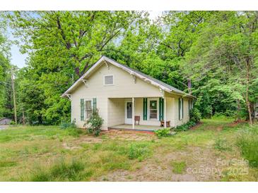 Quaint single-story home with a front porch, surrounded by mature trees and greenery at 252 7Th Se St, Hickory, NC 28602