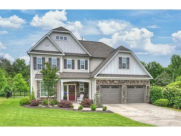 Charming two-story home with manicured lawn, stone accents, three car garage, and covered front porch at 2625 Rea Pond Ct, Charlotte, NC 28226