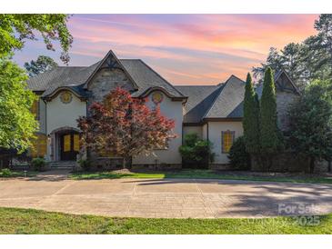 Charming home featuring a stone and stucco facade, elegant architectural details, and a well-manicured front yard at 277 Tradition Dr, Mount Gilead, NC 27306