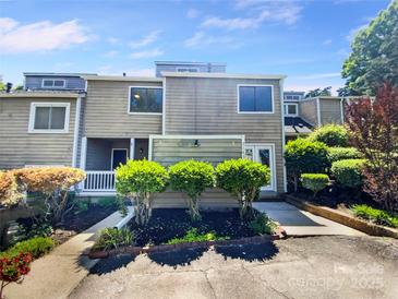 Inviting townhome featuring a neutral facade, manicured landscaping, and an attached front entry for added curb appeal at 3143 Windbluff Dr, Charlotte, NC 28277