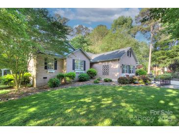 Charming brick home featuring a lush green lawn and mature trees, creating a serene and inviting exterior at 6005 Bryant Ln, Waxhaw, NC 28173