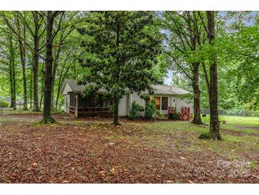 Charming single-story home with a screened porch, surrounded by mature trees and lush landscaping at 6804 Lineberger Rd, Denver, NC 28037