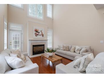 Bright living room with a fireplace, shuttered windows, and comfortable seating at 7722 Springs Village Ln # 40, Charlotte, NC 28226